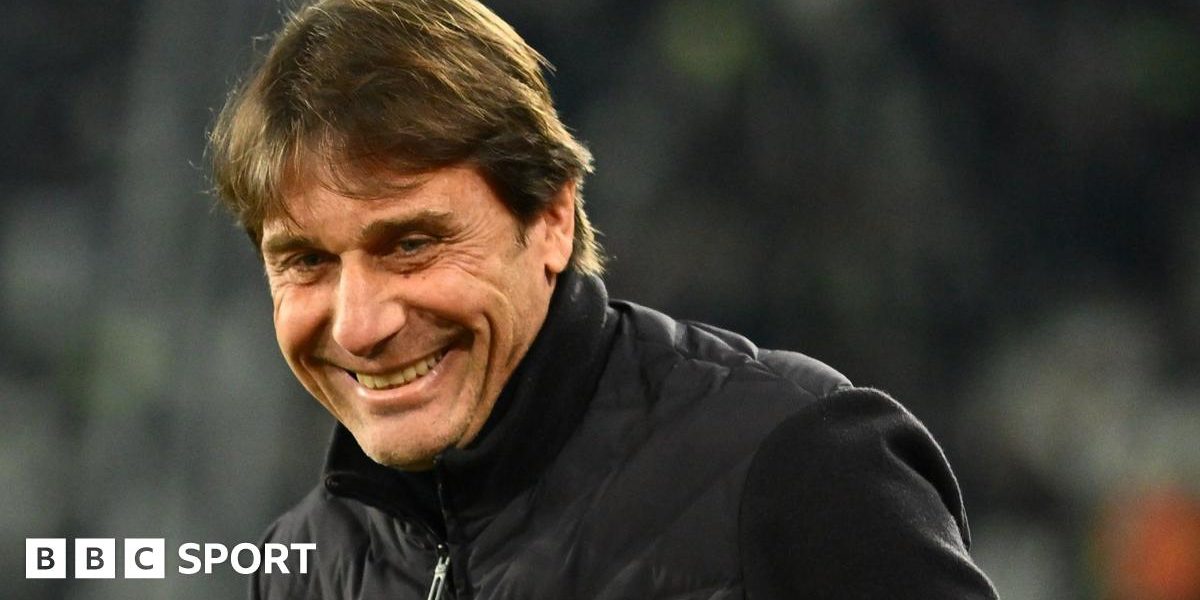 Head and shoulders view of a smiling Antonio Conte in a black, zipped-up jacket