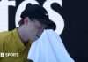 Jannik Sinner wipes his face with a towel
