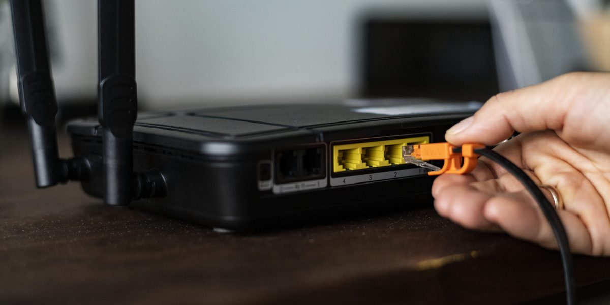 man-plugging-ethernet-cable-wireless-router-scaled.jpg - RevistaPolitica